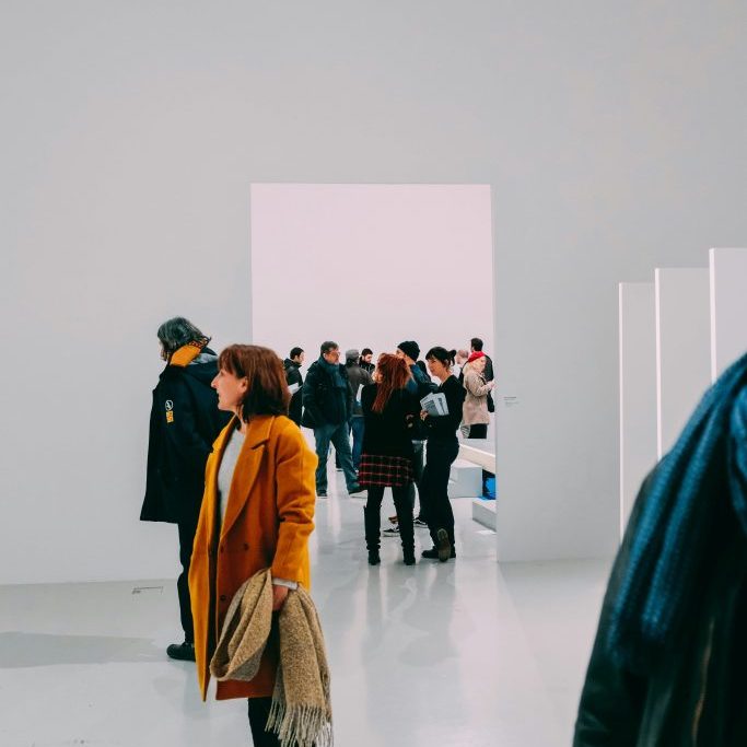 Group of people looking round a minimal modern art gallery