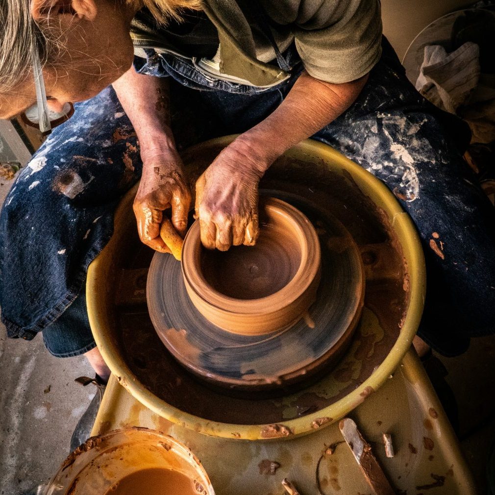 Pottery wheel class with a potter making a pot